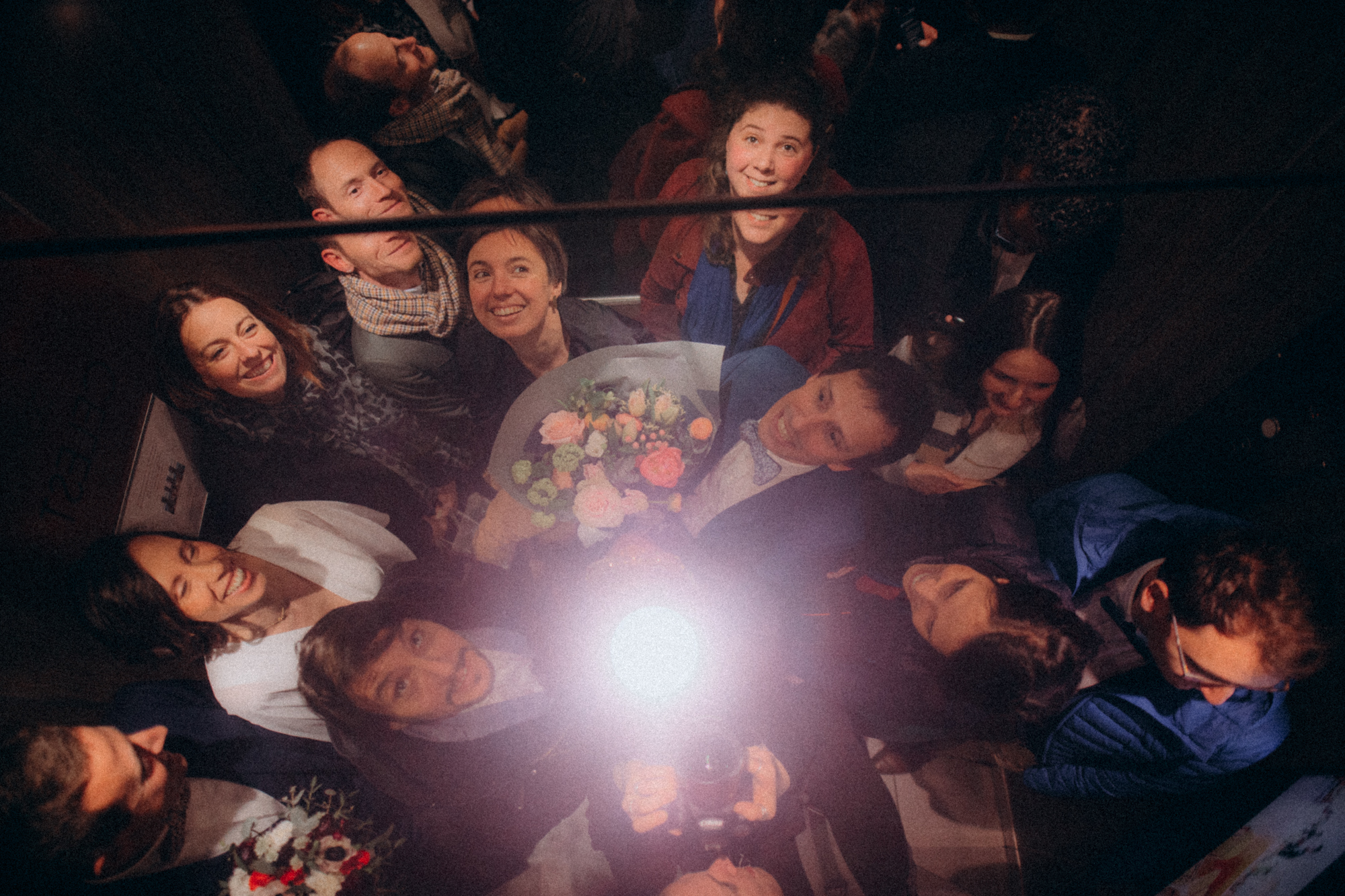 Groupe d'amis allongés en cercle, lumière flash, ambiance festive nocturne
