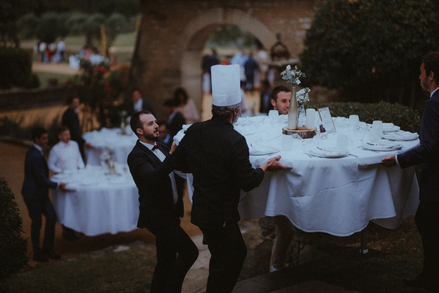 Tables de réception dressées au crépuscule, bougies et lumières douces
