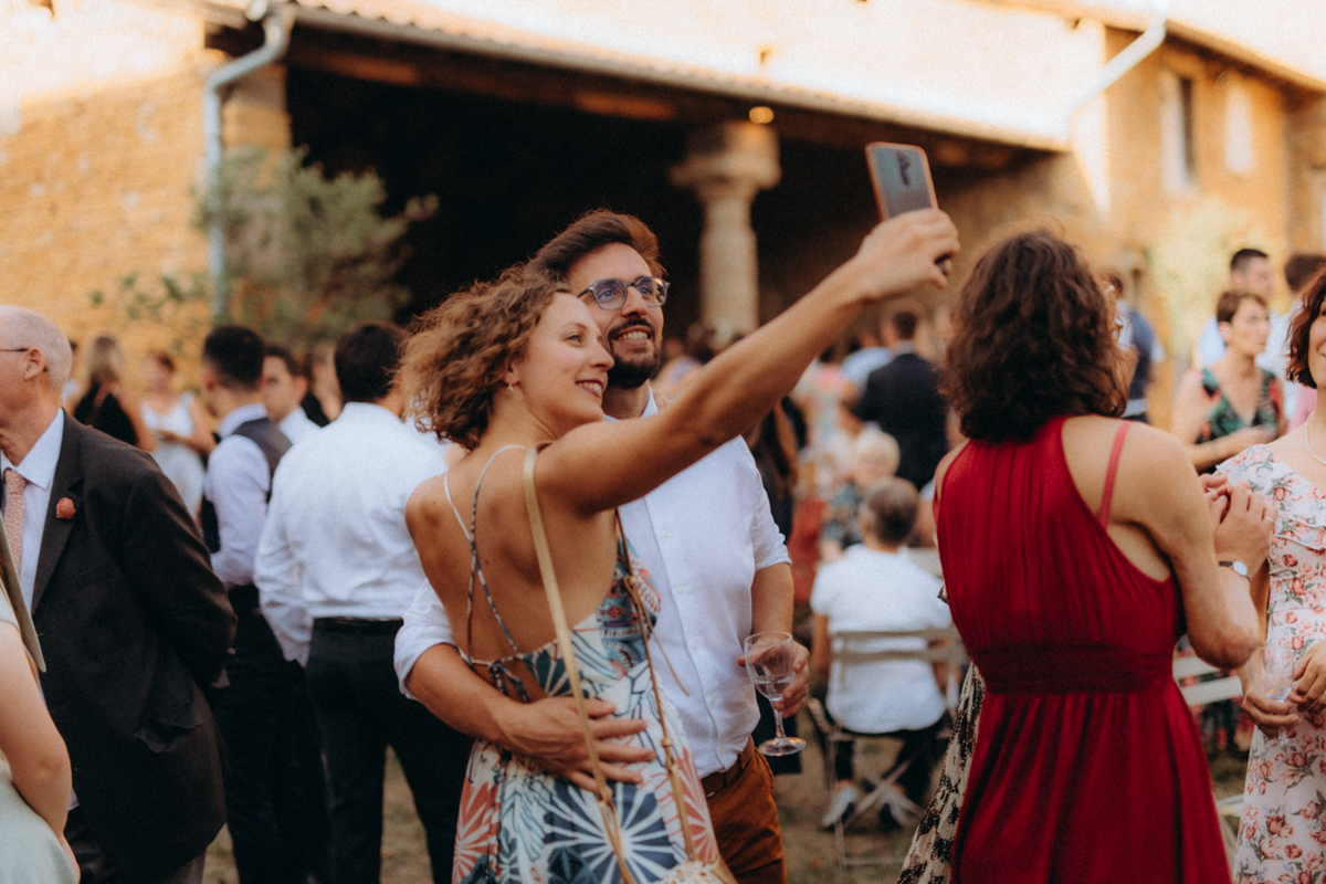 Invités qui dansent et s'embrassent lors d'un vin d'honneur en plein air

