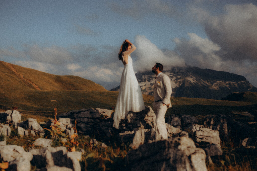 Mariée de dos sur les rochers en Chartreuse, robe blanche et paysage de montagne