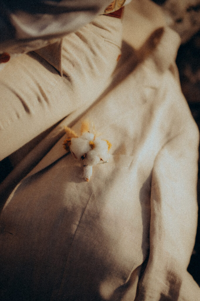 Gros plan fleurs de coton sur tissu blanc, détail séance noces de coton