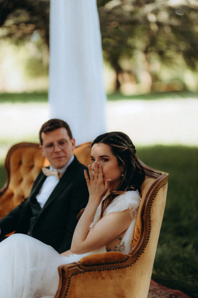 Mariée émue pendant le discours des invités en cérémonie laïque extérieure 