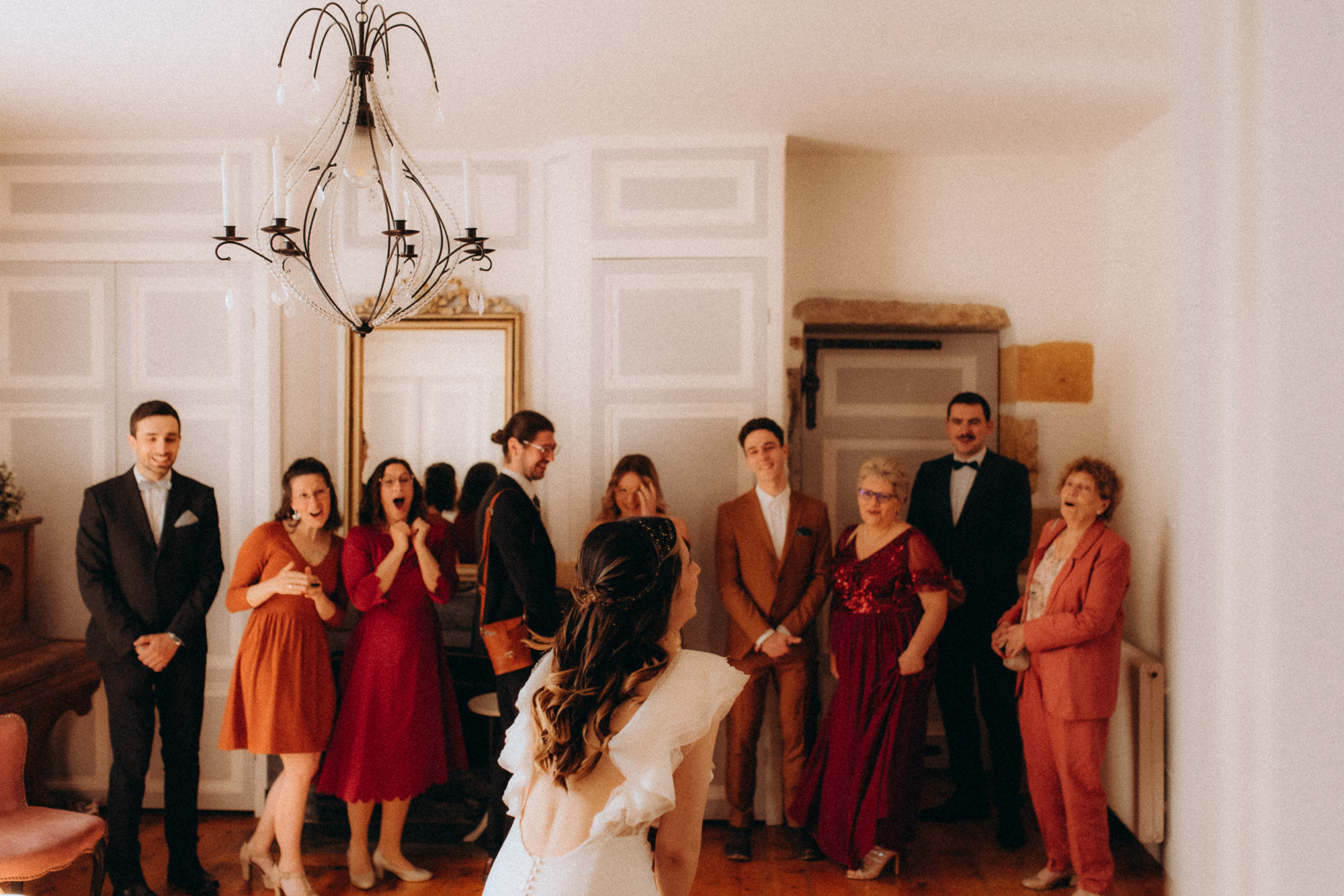 Portrait de groupe intérieur, découverte de la mariée lustre vintage, tenues colorées
