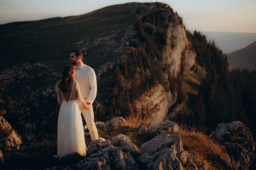 Couple enlacé sur un rocher en surplomb, paysage de Chartreuse au coucher de soleil