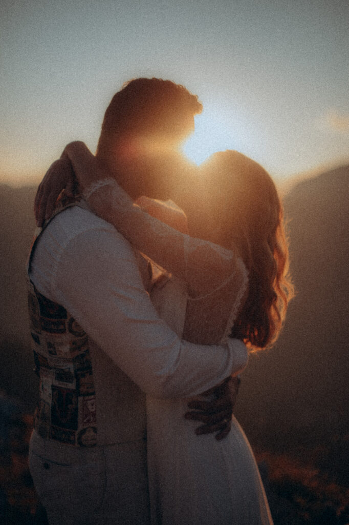 Couple enlacé au coucher de soleil, lumière dorée intense, Charmant Som
