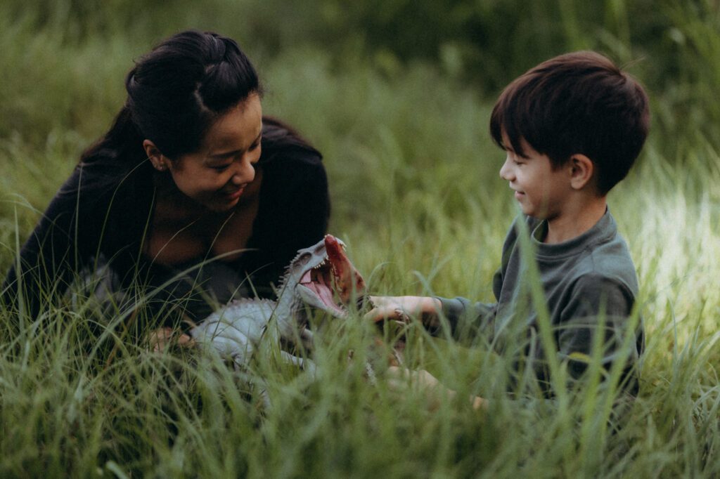Jen et Glenn dans un champ d'herbes hautes, lumière dorée de fin d'après-midi, séance photo famille naturelle