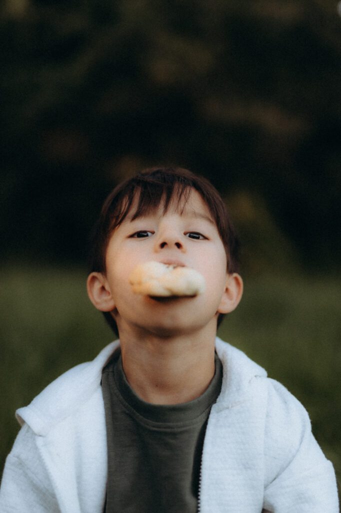 Portrait de Glenn souriant, enfant dans les herbes, séance photo famille authentique