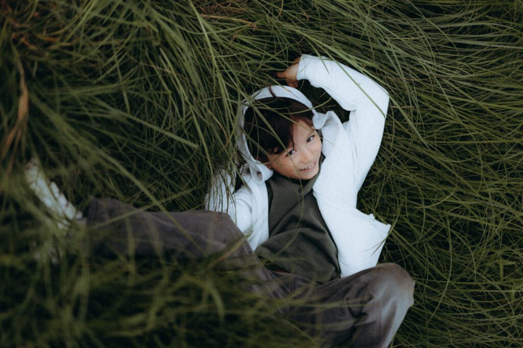 Glenn dans les feuilles, lumière tamisée, portrait enfant naturel
