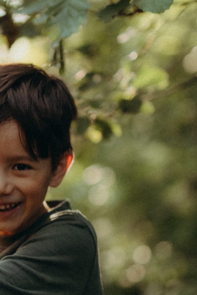 Portrait de Glenn souriant de près, lumière naturelle filtrée, photographe famille Lorelyne