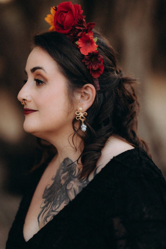 Profil de la mariée avec une couronne de fleurs rouges et orange, boucle d’oreille dorée