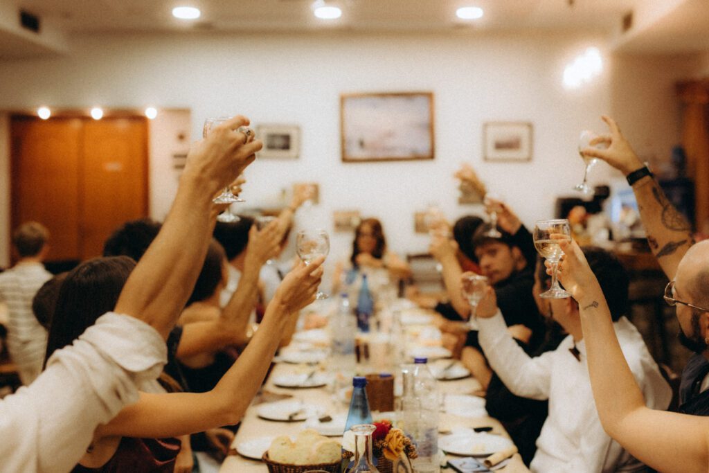 Invités levant leur verre autour de la longue table du repas de mariage en Crète
