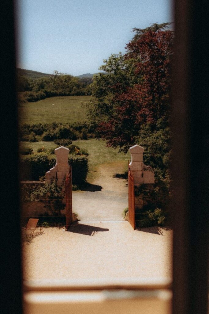  Vue sur la campagne à travers une porte-fenêtre du Domaine de Tourieux