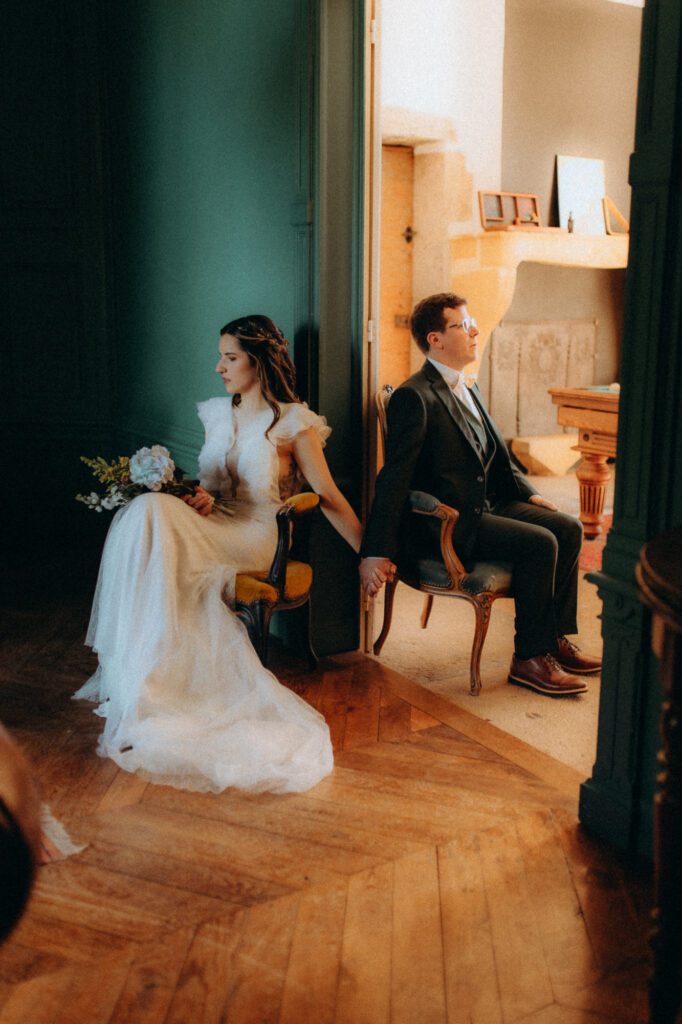 Blind look : mariée et marié assis de part et d'autre d'une porte, sans se voir